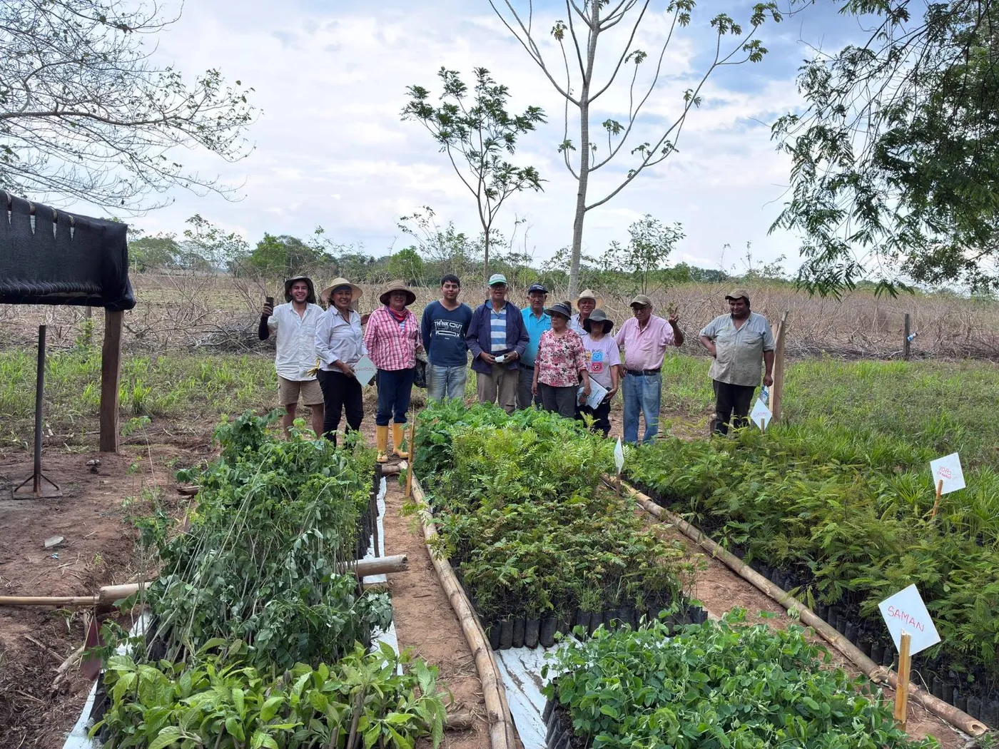 Integrantes de la asociación junto a las camas de plantas del vivero comunitario